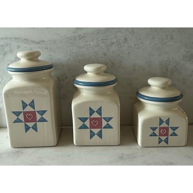 Set of 3 vintage ceramic canisters with cream glaze and hand painted blue quilted star pattern with a pink center heart....