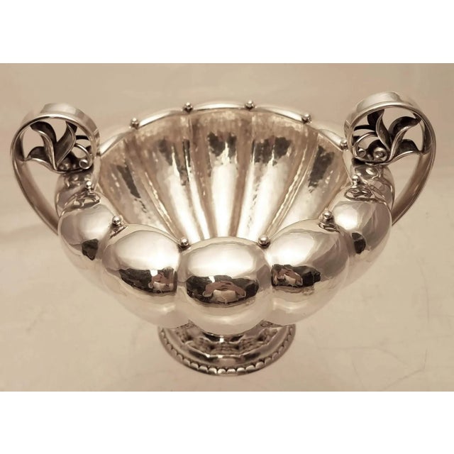 Sterling silver open sugar and creamer by Danish maker Georg Jensen. Designed in a repetitive lobed body, with upturned...