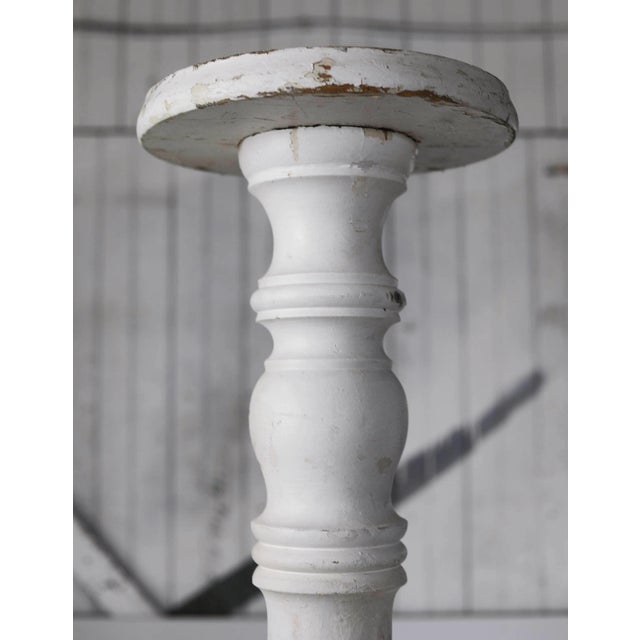 Pair of tall vintage wooden columns. White painted finish is distressed in areas.