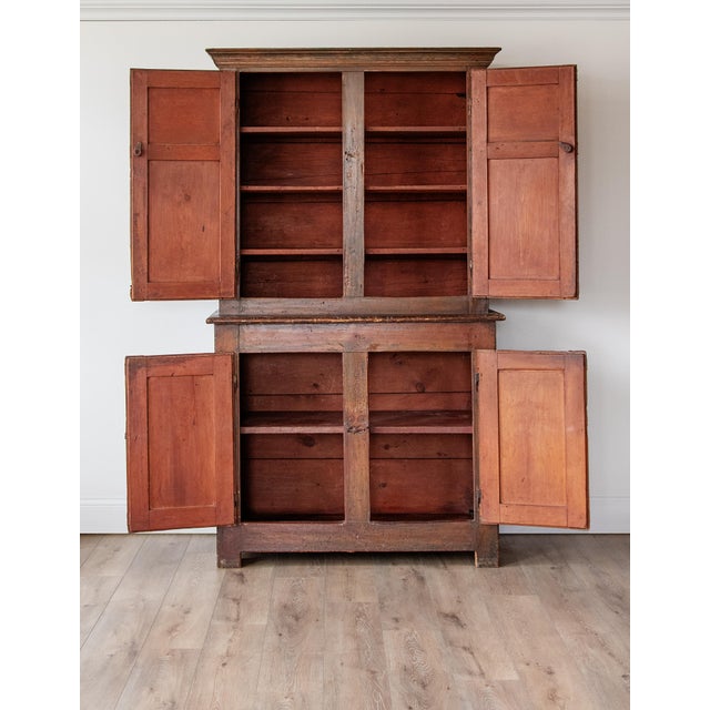 A beautifully timeworn early 19th-century American stepback cupboard, crafted in solid pine and retaining a deeply...