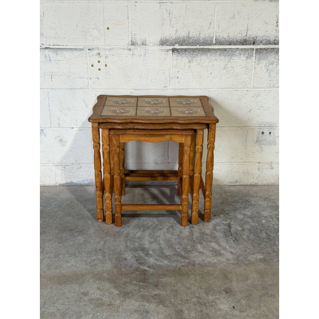 This set of three nesting tables features a space-saving design supported by turned spindle legs. The rectangular tops...