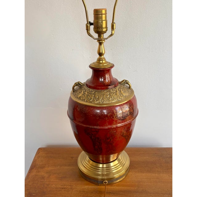 Incredible 1980s Mark Thomas table lamp with ornate brass relief details and painted oxblood red body. A wonderful...