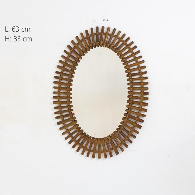 Description Oval-shaped wall mirror with perforated frame made of bamboo and rattan. The structure is composed of small...
