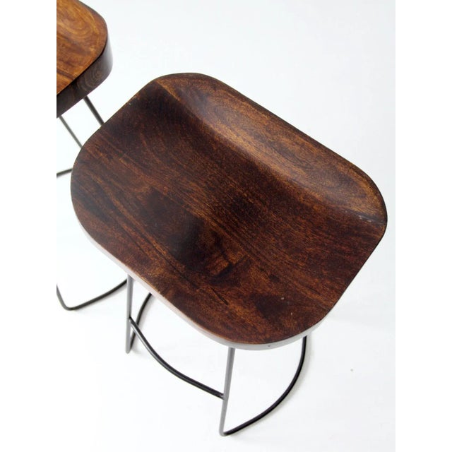 Late 20th Century Pair of Vintage Sculpted Wood Saddle Seat Bar Stools With Black Iron Bases For Sale - Image 5 of 11