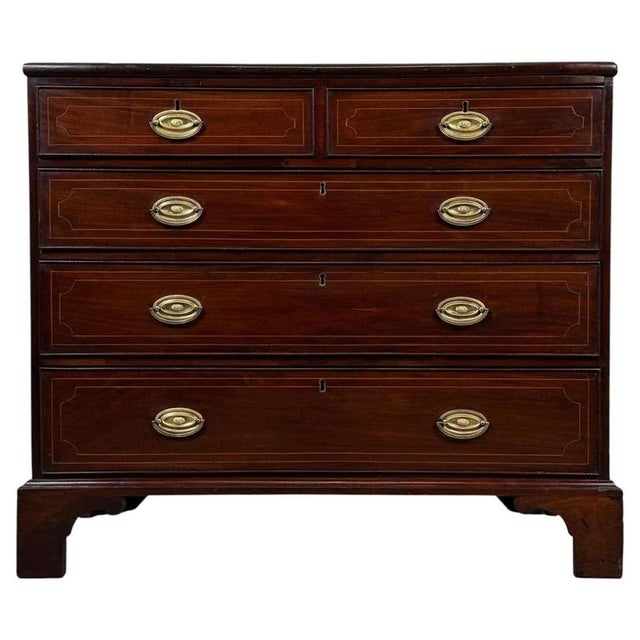 A refined 18th-century English chest of drawers, finely crafted from mahogany and distinguished by elegant satinwood...