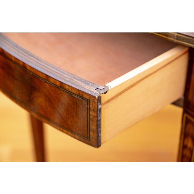 A Federal-style mahogany Pembroke drop-leaf table of quiet authority — satinwood inlaid square tapered legs, single drawer...