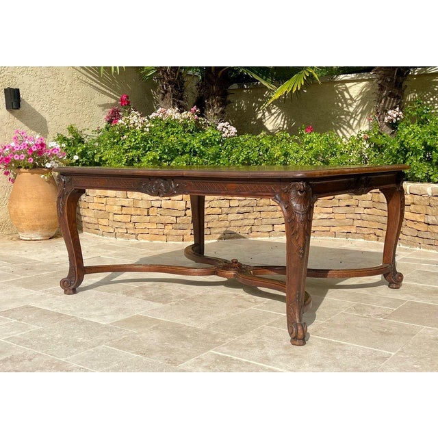 A beautiful Louis XV style dining table in solid oak, molded and carved, with four cabriole legs ending in a spiral...