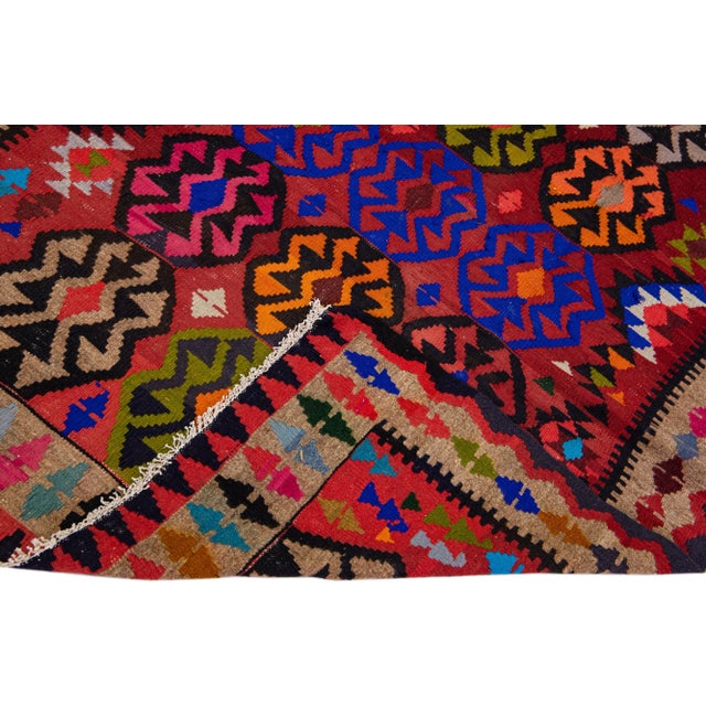 Beautiful vintage Turkish Kilim hand-knotted wool rug with a pink field. This piece has a tan frame and multicolor accents...