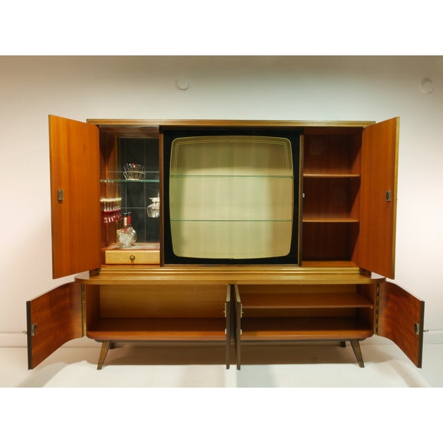 This piece of furniture consists of a base and upper section, combining a display cabinet, bar compartment, and storage...