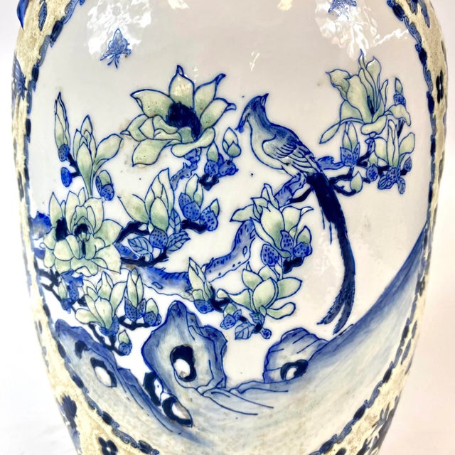 This unique late 20th century porcelain vase is blue, white, and light yellow with decorative blue flowers as handles. On...