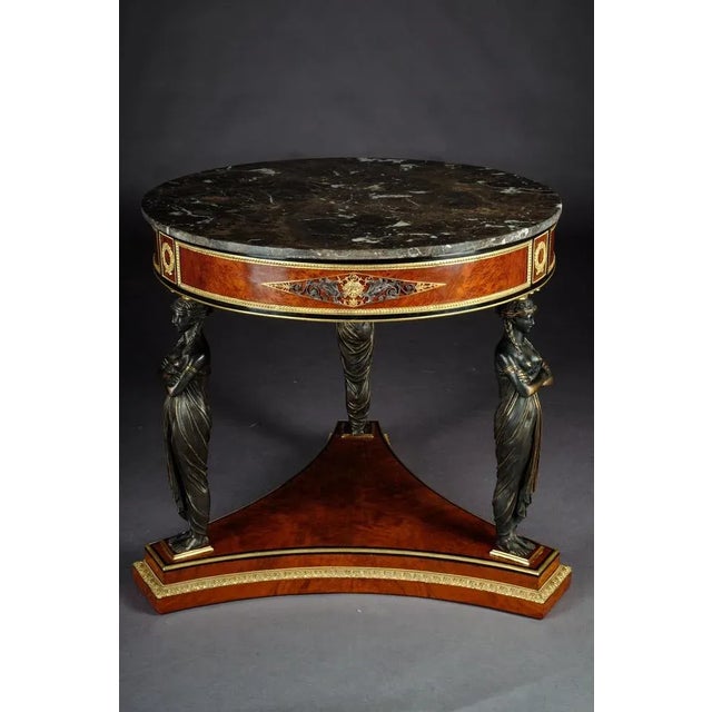 Spectacular Temple Guardian Empire style table Root on solid beechwood. A classicist table with three monumental, fully...