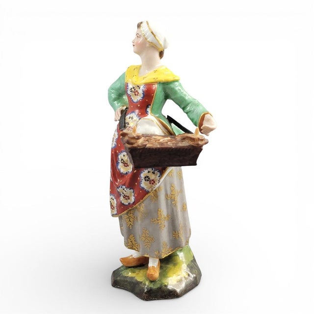 A late Georgian English porcelain figure produced at the Derby porcelain factory around 1800, representing a female street...