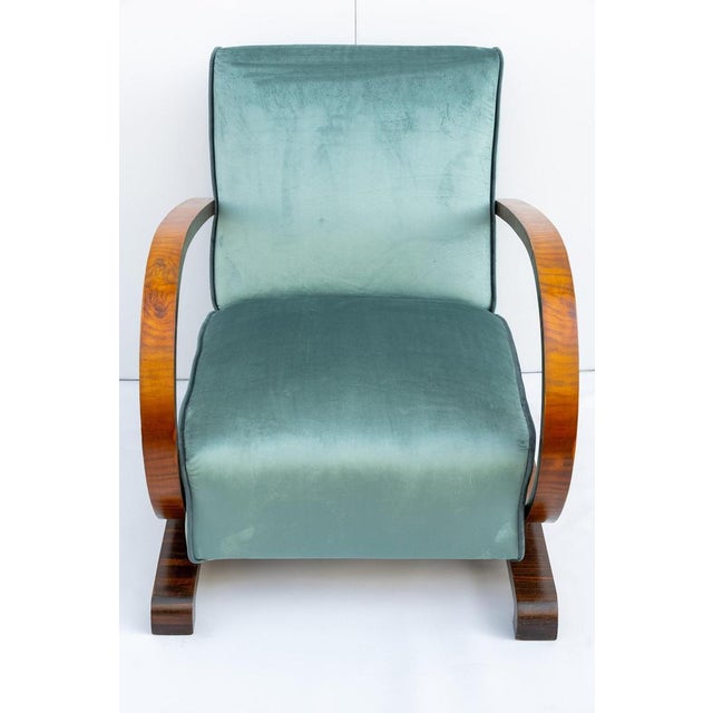 Art deco armchair, made in italy, 1930s. This art deco-style armchair features a wooden frame with semicircular armrests....