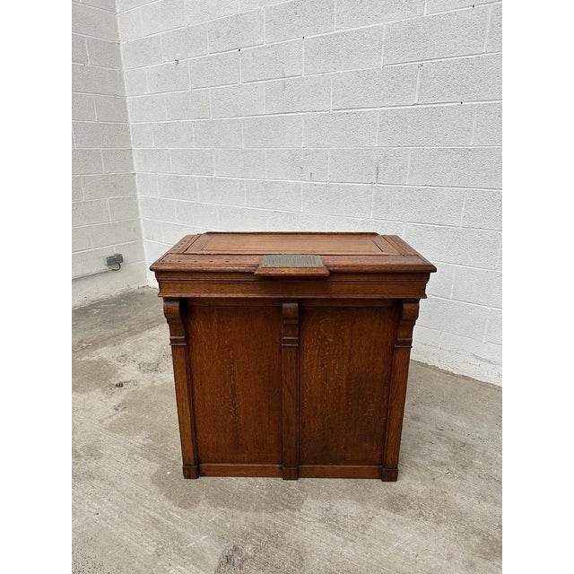 This old reception counter made of solid oak has been completely restored. Its front is decorated with crooks. It has a...