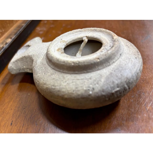 This is what is believed to be either an ancient or replica antique Terracotta oil lamp from the Herodian or Roman period,...