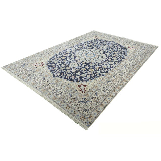 A classic Nain 9La rug, hand-knotted with a detailed medallion on a deep blue ground, enhanced by silk elements that...