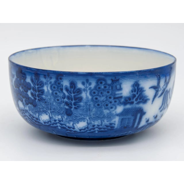 Decorative willow flow blue bowl. This design featured pagodas, trees, and birds. Flow blue is a style popular in Regency...