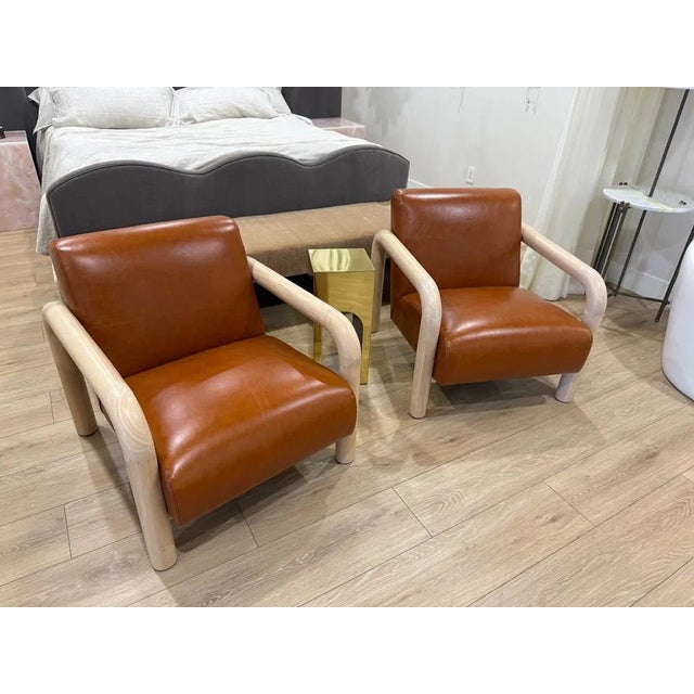 This pair of 1970s leather and lime oak armchairs is a set of two fully assembled antique chairs from the 1970s. The...