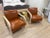 This pair of 1970s leather and lime oak armchairs is a set of two fully assembled antique chairs from the 1970s. The...