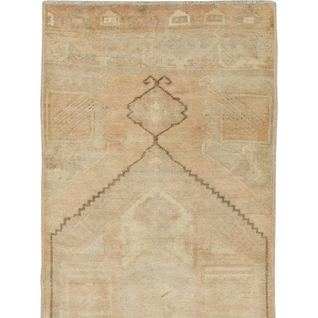 This mid-20th-century Turkish Anatolian runner presents a restrained composition centered on two large, vertically aligned...