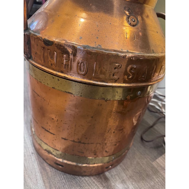 A substantial antique English copper milk churn embossed “United Dairies Wholesale Ltd.” and marked with the number “10.”...