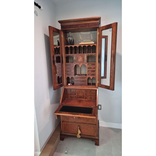 A statement secretary desk in the English George III manner. Burr wood veneers with fine stringing inlay cover the doors,...