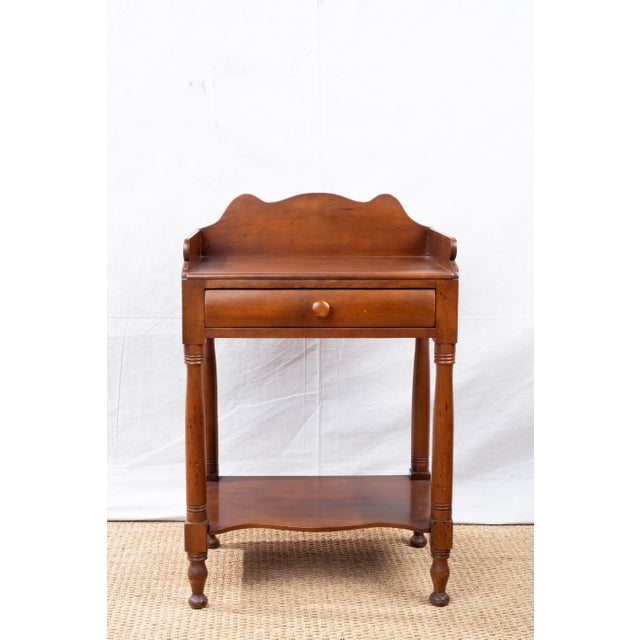 An antique mahogany washstand, late 19th century, American. Featuring a shaped wood gallery, single drawer with matching...