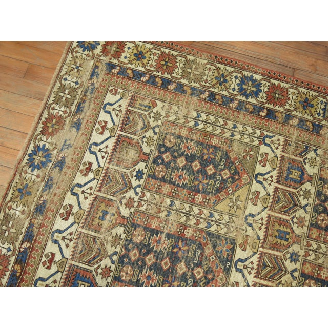 Throw size worn late 19th century Caucasian 3 x 5 rug in earthy palette. Rust, navy, Classic cluue, ivory. The wear is...