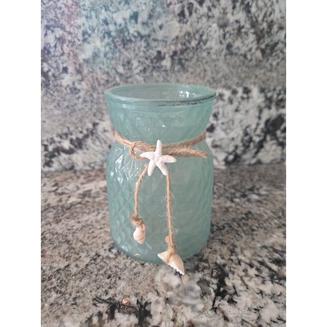 Blue glass vase with seashells 3.5 inches diameter and 5 inches tall. Great condition.