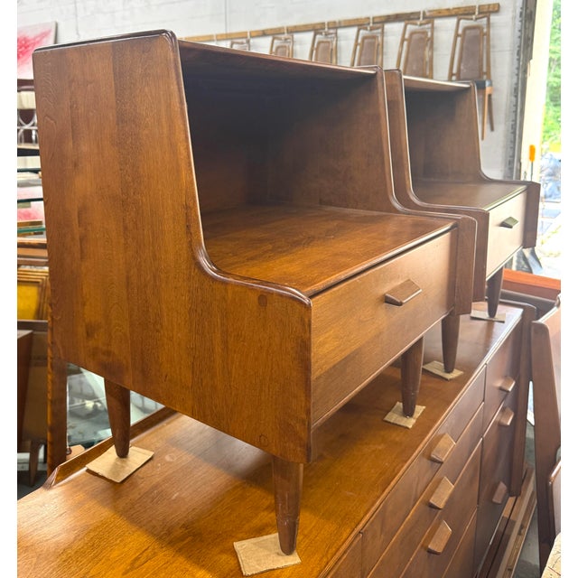 This vintage mid-century modern nightstand with a lower open compartment and a single integrated drawer, designed by...
