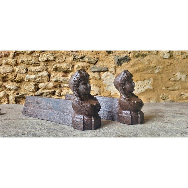 Pair of 19th-century cast iron andirons. Height 20 cm. Width 10 cm. Depth 39 cm. Signs of wear and age / The andirons have...