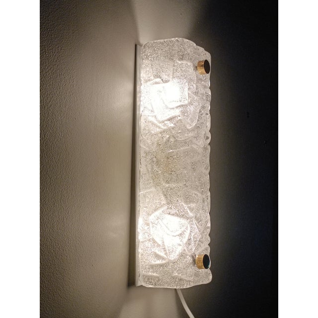 Magnificent wall sconce by Carl Fagerlund for Orrefors. Sweden, 1960s. White lacquered metal wall structure. It supports a...