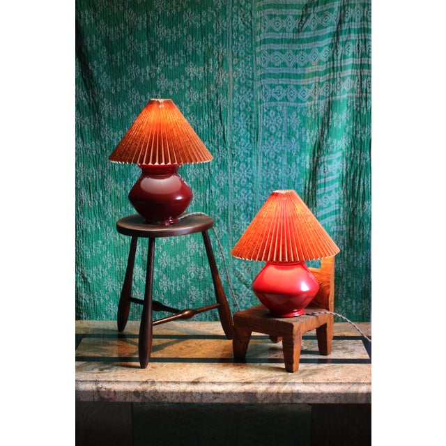 A pair of red glass painted table lamps in the Art Deco style. New clip on orange (or terracotta) colored shades in fabric...