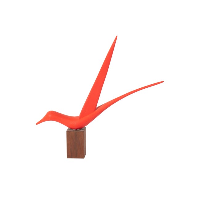 A wood sculpture of a bird by the Canadian artist Maurice Cotnoir (1929-2024). This delicate red bird is posed on a...