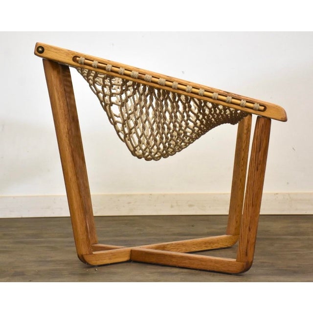 A solid oak frame net chair with a woven rope seat. Made in USA. Circa 1970’s. Seat height is 16”. 31.75” wide. 29” deep....