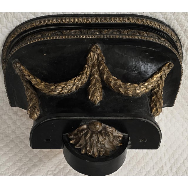 This late 19th century wall bracket shelf features a sculptural demi-lune form with richly carved classical ornament. The...