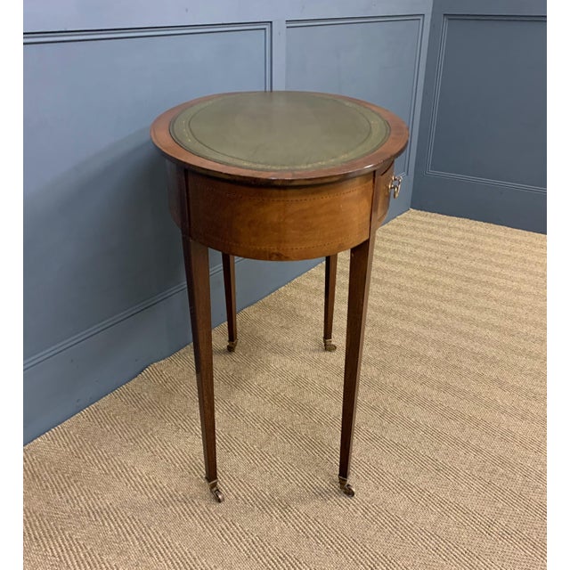 A very good Edwardian period inlaid mahogany oval shaped writing table. Decorated throughout with boxwood stringing and...