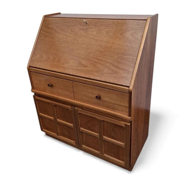 This teak writing bureau is a beautifully crafted mid century desk designed to serve as a compact writing bureau that...