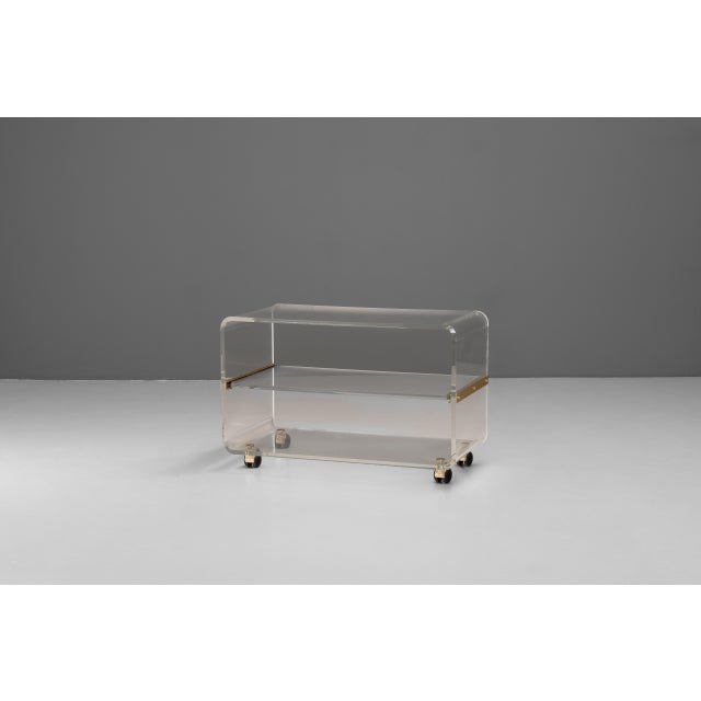 French acrylic trolley / side table on roller casters with pull-out shelf. Circa 1970.