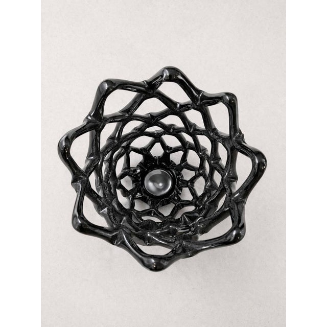 Bold sculptural presence -this heavy, thick-glass vessel is finished in a high-gloss black and hand-formed into an open...