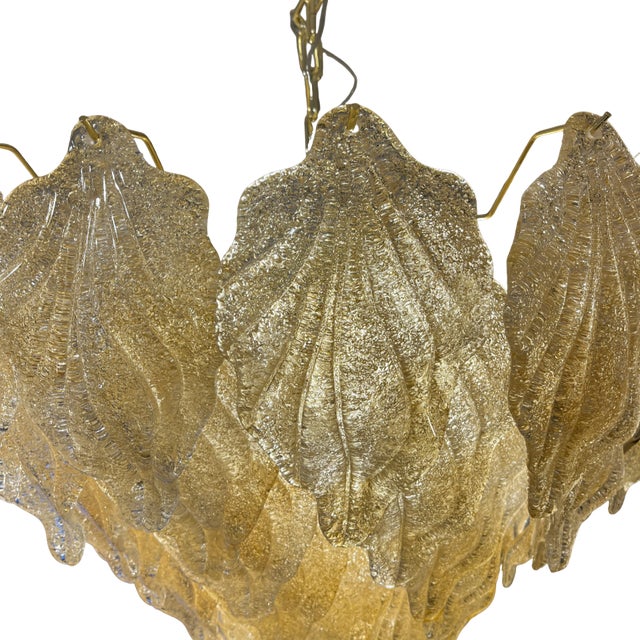 Ceiling lamp with Murano glass in a golden tone. Its eight-tiered design creates a cascading effect over a circular,...
