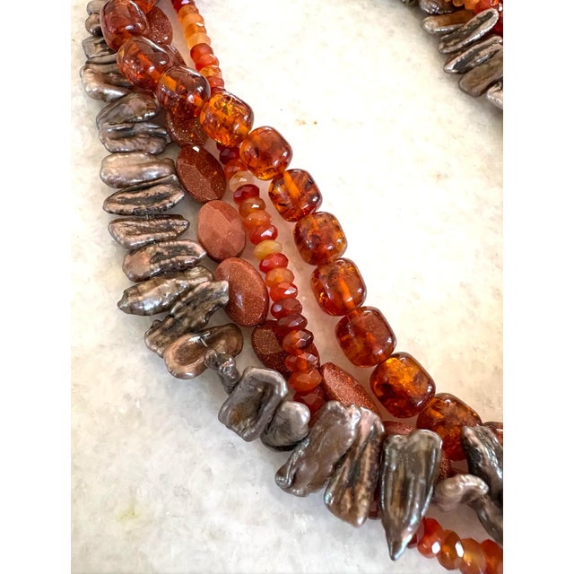 Stunning, four strand necklace featuring a collection of faceted carnelian beads, uniquely shaped freshwater pearls (each...