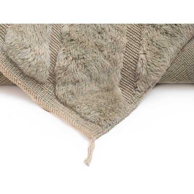 A landscape you can feel: carved channels and raised paths, sculpted entirely in wool. Deep, plush ridges wind across a...