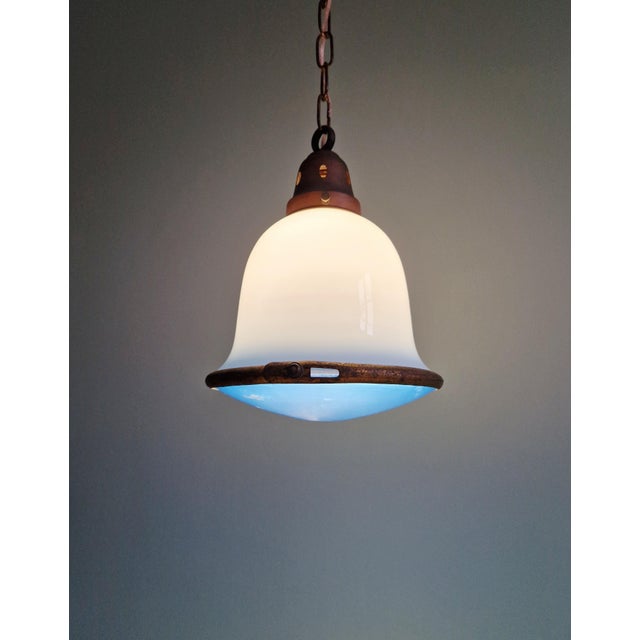 Bauhaus pendant light from the 1920s, featuring a white and blue opaline glass globe at the top and a blue frosted glass...