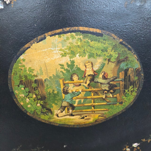An exceptional antique English papier-mâché tray featuring a richly lacquered black finish, delicate hand-painted floral...