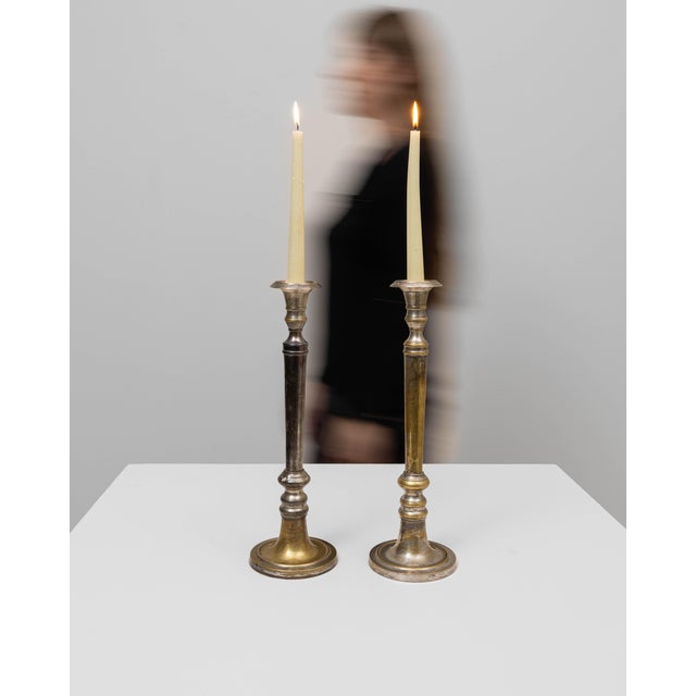 This pair of 20th Century French brass candlesticks displays an elegant, timeworn character shaped by decades of natural...