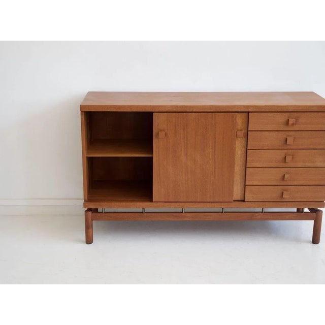 Sideboard made of teak wood with sliding doors and five drawers, brass details. Manufactured in Italy by La Permanente...