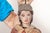 A large wooden marionette of a crowned princess figure, painted with a fair complexion and dark hair beneath a tarnished...