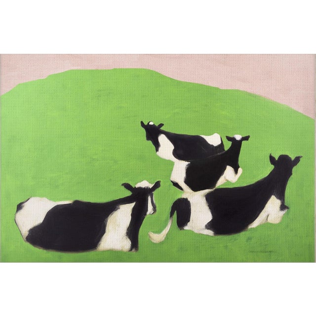A canvas print of a group of black and white cows on a green grassy hill with a rosy pink sky, floated in a natural light...