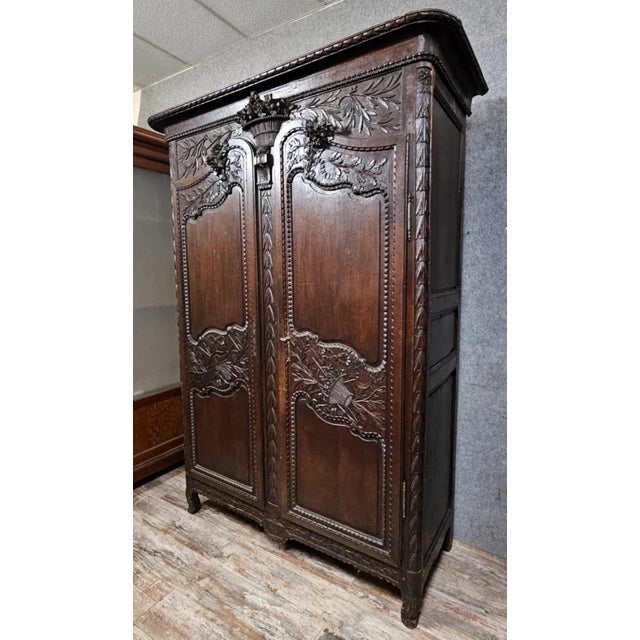 Large Norman wedding armoire in carved oak – Louis XV period Superb antique armoire in solid wood, richly carved, of very...
